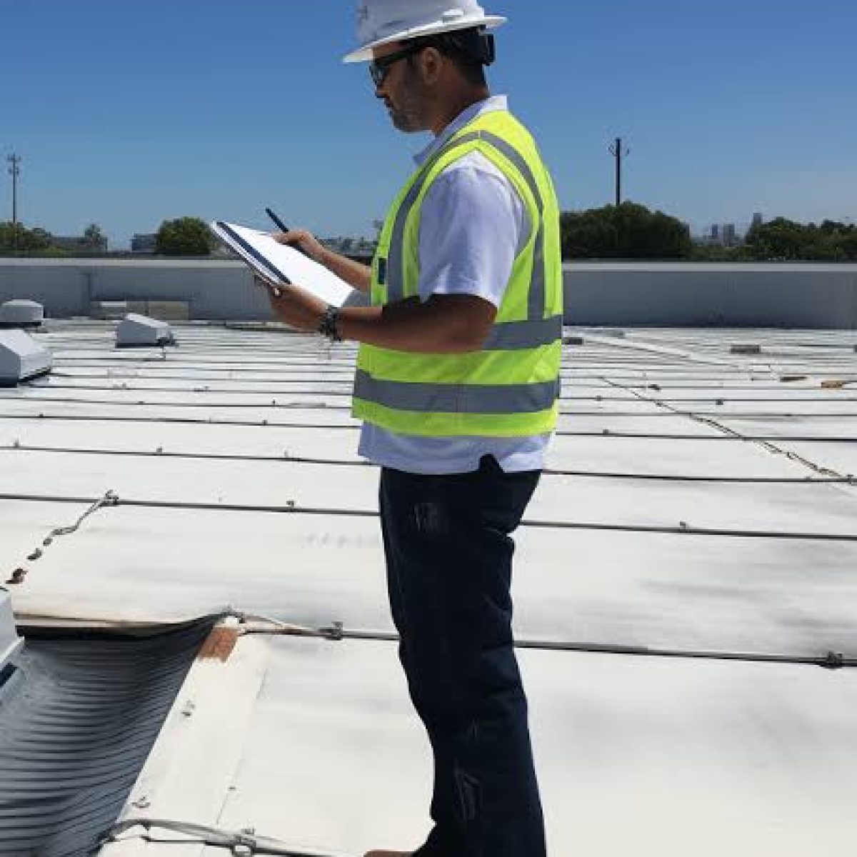 Commercial roofing professional inspecting a flat roof